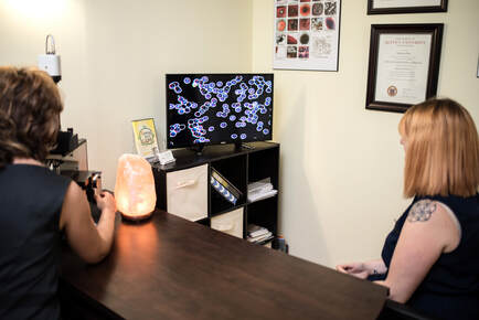 Marianna Duba showing a client her live blood cell analysis image